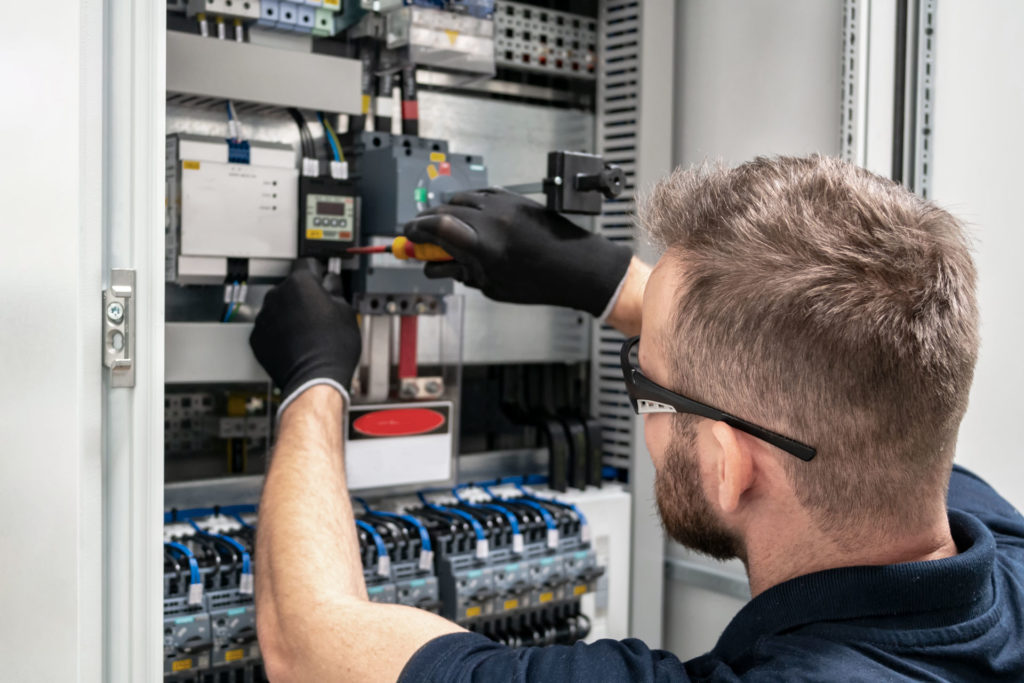 symbolic picture man with gloves screwing with a screwdriver in a cupboard