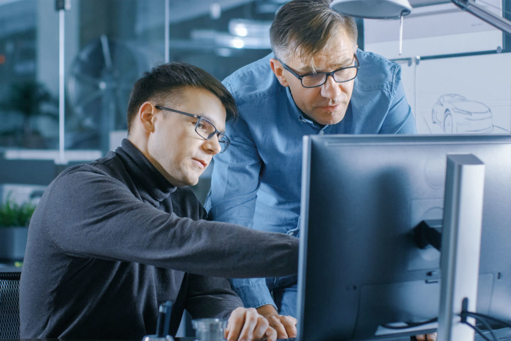 symbolic image planning and consultation two men in blue discussing in front of a screen